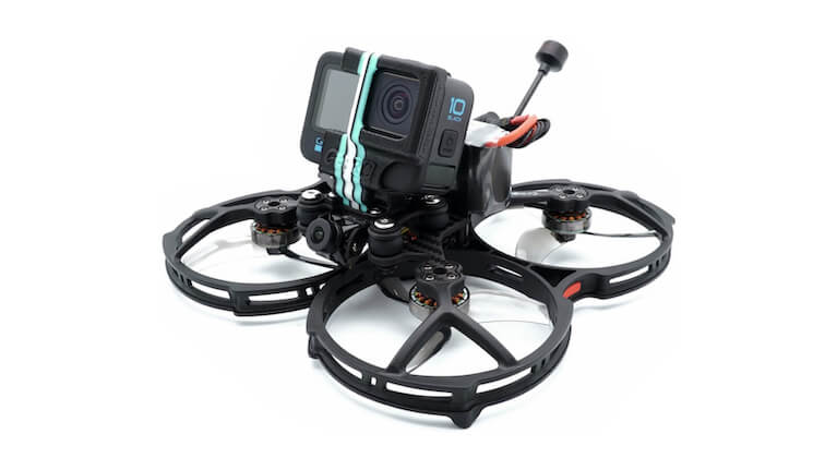 An FPV drone with prop guards carrying a GoPro.